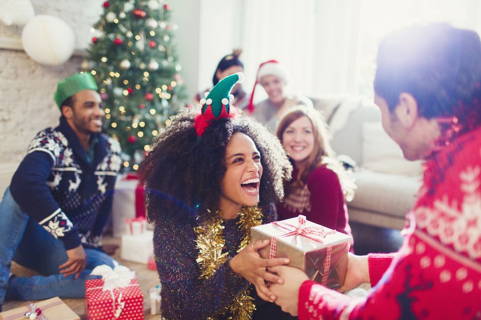 enthusiastic friends exchanging Christmas gifts