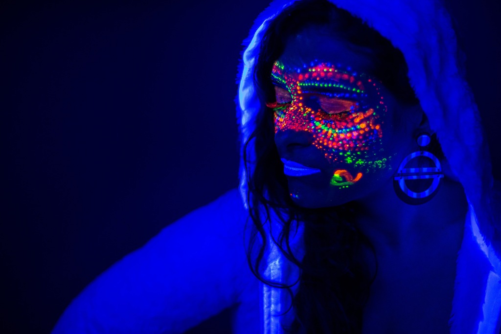 DJ black lights glow on a neon painted face