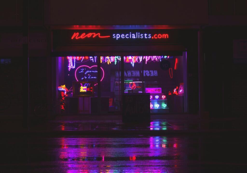 A dark street full of billboards and neon lights